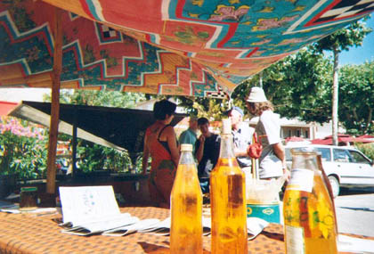 3 bouteilles d'huiles sur un stand sous la tente